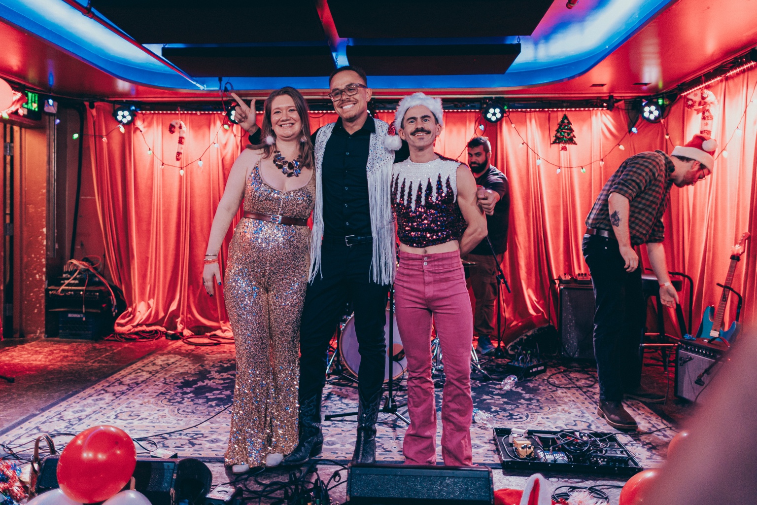 Three people posing together on the festive Holly Jolly stage